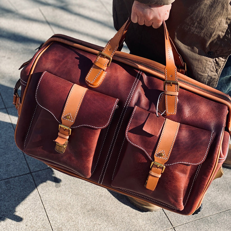 Handmade Leather Travel Bag With Wheels, 23.6in carry on rolling duffel, shown being held
